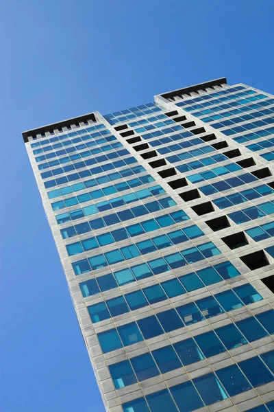 Modern glassy skyscraper against the blue sky.