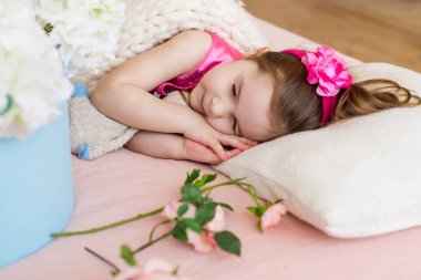 Kız yatak, baş ve flo Pembe çiçek üzerinde uyuyor