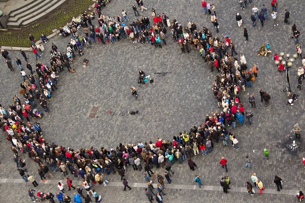 La gente en la plaza se reunió en un círculo alrededor del músico para —  Fotos de Stock