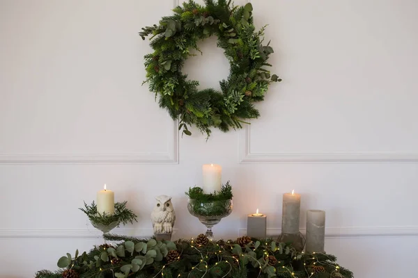Green Christmas wreath with decorations on white wall — Stock Photo, Image