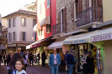 Sirmione, İtalya - Ekim 2017 yaklaşık: Mağaza ve kafe Sirmione'da sokakta yürüyen turist çok. İtalya ünlü turistik yer.
