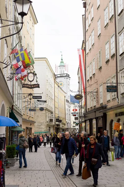 Centro histórico calle con gente, letreros de tiendas y arquitectura antigua —  Fotos de Stock