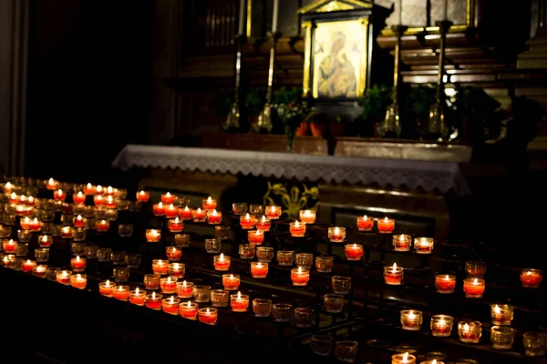 Filas de velas llamas brillando en la oscuridad . —  Fotos de Stock