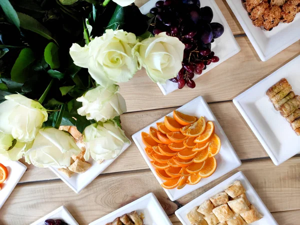 宴会服务 提供不同的小吃 水果和曲奇等配餐 用白玫瑰花装饰的木制餐桌 — 图库照片