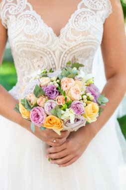 Çiçekli gelin, yakın çekim manzaralı. Düğün buketi, arka planda elbise..