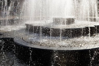 Bahar çeşmesine su sıçrat ve damla. Su düşüyor, yakın çekim. Fondü su ayrıntıları.