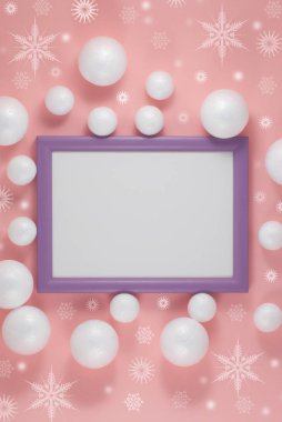 Resim çerçevesi ve pembe arka planda noel süsü. Düz yatıyordu. Parti maketi. Davetiye ya da tebrik kartı.