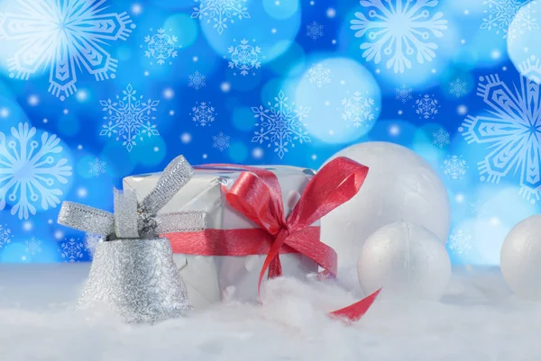Composición navideña con caja regalo o regalo y bolas de nieve decorativas contra fondo de luces navideñas — Foto de Stock