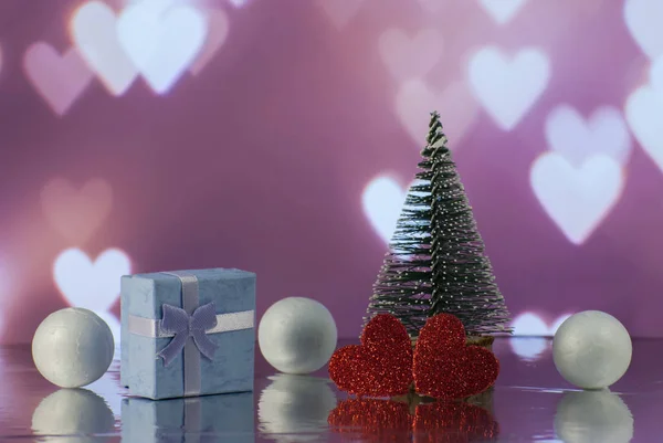 Christmas composition with Christmas tree, Hearts, gift or present box and decorative snowballs against holiday lights — ストック写真