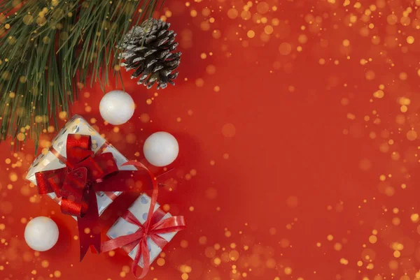 Fondo de Navidad con hermoso regalo o caja de regalo, conos de pino nevado y bolas de nieve decorativas, vacaciones. Vista superior — Foto de Stock