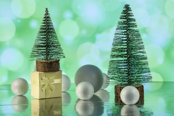 Christmas composition with Christmas tree, gift or present box and decorative snowballs against holiday lights — ストック写真