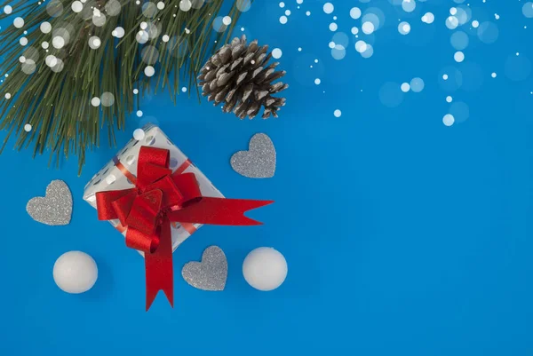 Navidad y Año Nuevo fondo de vacaciones. Tarjeta de felicitación. Regalo de cinta roja de Navidad y adornos sobre fondo azul — Foto de Stock