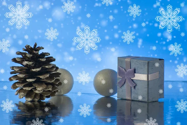 Новорічна композиція з подарунковою або подарунковою коробкою, сосновим конусом та декоративними сніжками на фоні святкових вогнів — стокове фото