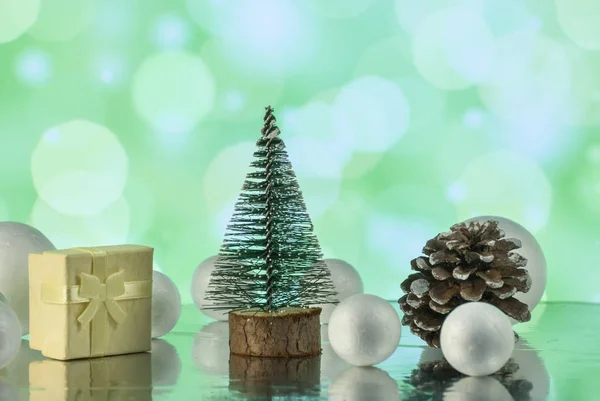Новорічна композиція з ялинкою, подарунковою або подарунковою коробкою та декоративними сніжками на святкових вогнях — стокове фото