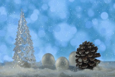 Noel ağacı, çam kozalağı ve dekoratif kartoplarıyla Noel ışıkları arka planında