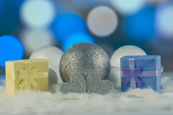Новорічна композиція з подарунковою або подарунковою коробкою та декоративними сніжками на фоні святкових вогнів — стокове фото