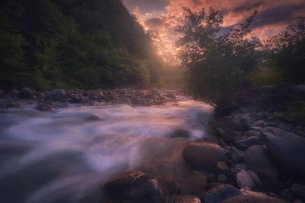 Волшебный закат над быстротекущей горной рекой — стоковое фото