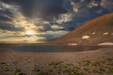 Dağ gölünün üzerinde kurulmamış güzel bir sıcaklık. Yaz akşamı manzarası