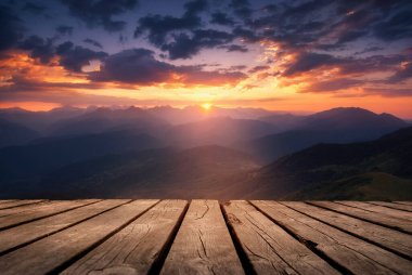Güzel bir arka plan, dağların üzerinde gün doğumu ve doğada boş ahşap bir masa. Doğal şablon manzarası