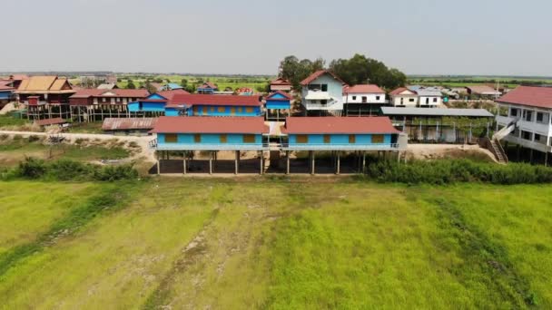 Campos de arroz desde arriba en un día ventoso revelando la escuela tradicional pintada de azul — Vídeos de Stock