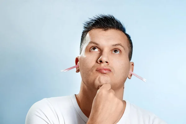El hombre con la ayuda de un hisopo higiénico de algodón está leyendo su oreja. El concepto de higiene corporal . — Foto de Stock