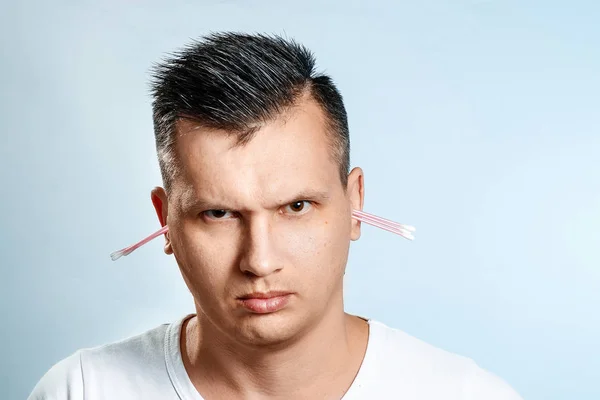 Человек с помощью гигиенического ватного тампона читает его ухо. Концепция гигиены тела . — стоковое фото