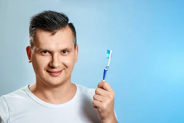 Чоловік тримає зубну щітку, чистить зуби. Поняття гігієни ротової порожнини . — стокове фото