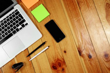 Rustik, işçi, ahşap masa üstü görünümü, düz. İş öğeleri tablo, dizüstü bilgisayar, telefon, kalemler, çıkartmalar. İş öznitelikleri kavramı. Kopya alanı.