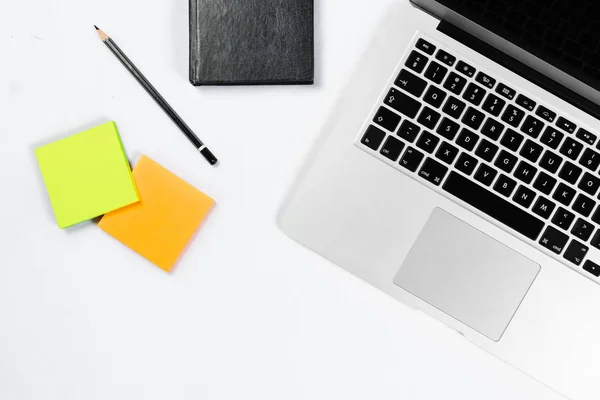 Mesa de trabajo vista superior, plano laico. Artículos de negocios en una mesa blanca, portátil, reloj, teléfono, bolígrafos, pegatinas. Espacio de copia, Concepto de atributos de negocio . —  Fotos de Stock