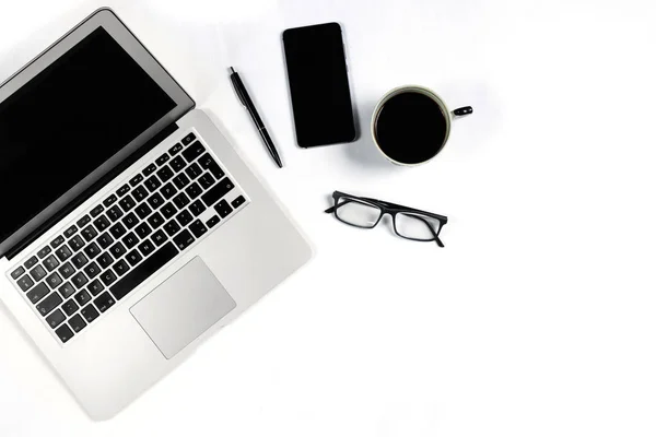 Mesa de trabajo vista superior, plano laico. Artículos de negocios en una mesa blanca, portátil, reloj, teléfono, bolígrafos, pegatinas. Espacio de copia, Concepto de atributos de negocio . —  Fotos de Stock