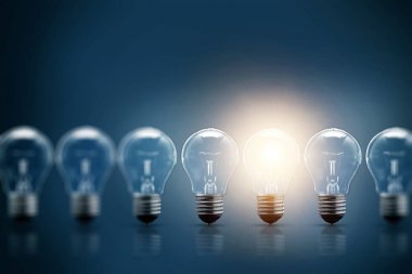 Bir dizi elektrik ampulleri, tek, karanlık bir arka planda parlıyor. Birkaç denemeden, başarılı bir konsept. Başarılı bir fikir.