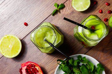 Yeşil kokteyl cam kivi, yeşil elma, limon, nane ve granate. Kavram sağlıklı bir diyet, detoks. Serinletici bir içki. Yukarıdan görüntülemek.