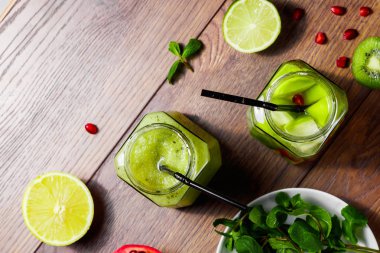 Yeşil kokteyl cam kivi, yeşil elma, limon, nane ve granate. Kavram sağlıklı bir diyet, detoks. Serinletici bir içki. Yukarıdan görüntülemek.