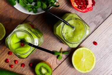 Yeşil kokteyl cam kivi, yeşil elma, limon, nane ve granate. Kavram sağlıklı bir diyet, detoks. Serinletici bir içki. Yukarıdan görüntülemek.