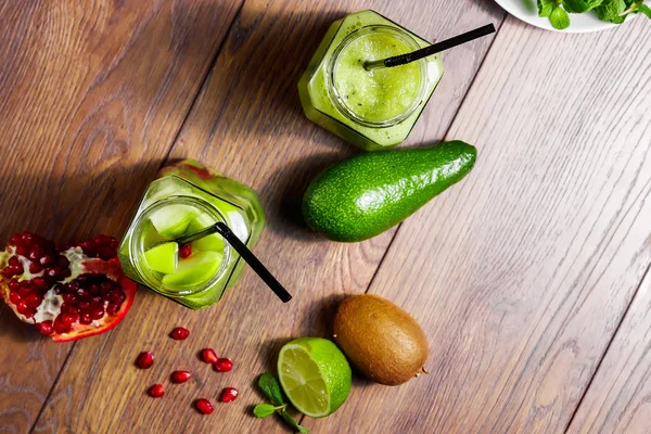 Green cocktail in a glass jar of kiwi, green apple, lime, mint and granate. The concept of a healthy diet, detox. A refreshing drink. View from above.