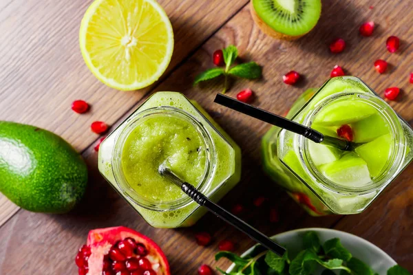 Zöld koktél egy üvegedénybe, kiwi, zöld alma, lime, menta és granate. A koncepció az egészséges táplálkozás, méregtelenítés. Egy frissítő italt. Nézd meg felülről. — Stock Fotó