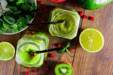 Yeşil kokteyl cam kivi, yeşil elma, limon, nane ve granate. Kavram sağlıklı bir diyet, detoks. Serinletici bir içki. Yukarıdan görüntülemek.