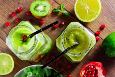 Yeşil kokteyl cam kivi, yeşil elma, limon, nane ve granate. Kavram sağlıklı bir diyet, detoks. Serinletici bir içki. Yukarıdan görüntülemek.