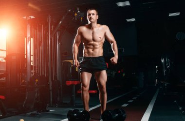 Kaslı atletik vücut fitness model spor salonunda egzersiz sonra poz