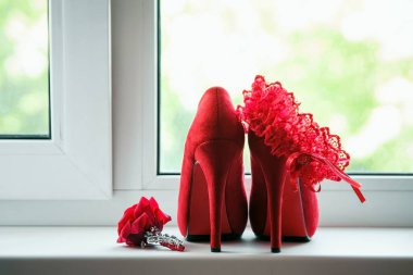 Red women's shoes stand on the windowsill, wedding, boutonniere. clipart