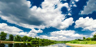 Güzel bir yaz kırsalında nehir ve mavi gökyüzünde bulutlar. - Rusya. Ural. Sloboda Köyü