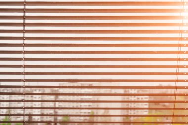 Beyaz güneşlikler pencereden gelen günbatımında görüntülemek