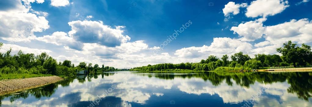 Beautiful summer rural landscape with river and clouds on the blue sky. Russia. Ural. Village Sloboda