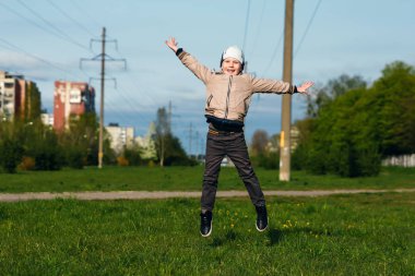 Altı oynarken, atlama, çalıştıran, parkta gülümseyen yaşında yakışıklı çocuk. Metin için yer