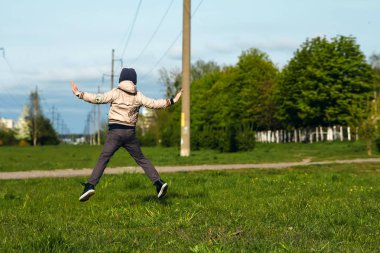 Altı oynarken, atlama, çalıştıran, parkta gülümseyen yaşında yakışıklı çocuk. Metin için yer