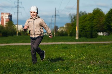 Altı oynarken, atlama, çalıştıran, parkta gülümseyen yaşında yakışıklı çocuk. Metin için yer