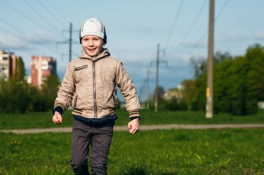 Altı oynarken, atlama, çalıştıran, parkta gülümseyen yaşında yakışıklı çocuk. Metin için yer