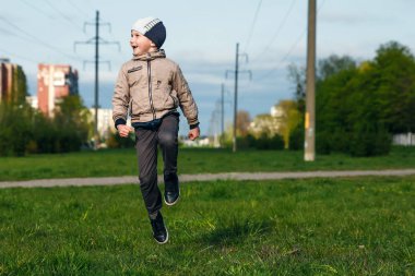 Altı oynarken, atlama, çalıştıran, parkta gülümseyen yaşında yakışıklı çocuk. Metin için yer
