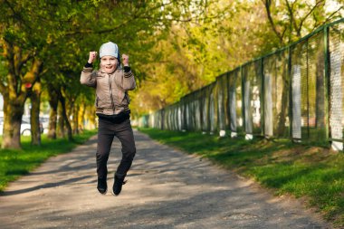 Altı oynarken, atlama, çalıştıran, parkta gülümseyen yaşında yakışıklı çocuk. Metin için yer