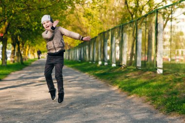 Altı oynarken, atlama, çalıştıran, parkta gülümseyen yaşında yakışıklı çocuk. Metin için yer